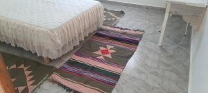 a room with two rugs on the floor next to a bed at Dar Souade in Chott Meriem
