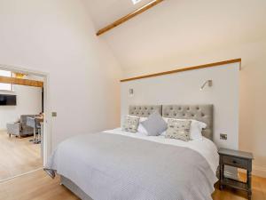 een slaapkamer met een groot wit bed met kussens bij 1 Bed in Filey 79277 in Wold Newton