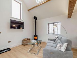 a living room with a couch and a fireplace at 1 Bed in Filey 79277 in Wold Newton