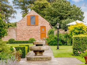 a house with a garden with a fountain in front of it at 1 Bed in Filey 79277 in Wold Newton