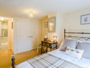 a bedroom with a bed and a table and a door at 2 bed property in Exeter 79431 in Sandford