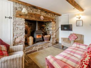 a living room with a stone fireplace with two chairs at 2 bed in Llangynidr BN023 in Llangynidr
