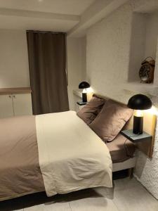 um quarto com uma cama e duas lâmpadas sobre uma mesa em Le coteau 3 chambres em Charmes