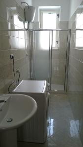 a white bathroom with a shower and a sink at STELLA appartamento in Policoro