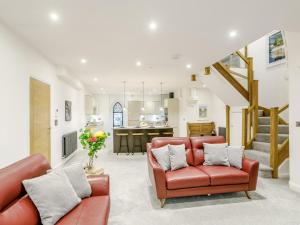 Una sala de estar con sillas de cuero rojo y una cocina. en 2 Bed in Matlock 80535, en Matlock