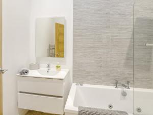 Un baño con lavabo, bañera y espejo. en 2 Bed in Matlock 80535, en Matlock