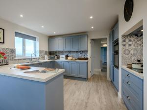 a kitchen with blue cabinets and a white counter top at 3 Bed in Worth Matravers 80578 in Worth Matravers