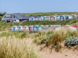 a row of colorful houses on a beach at 2 Bed in Bude 82163 in Bude