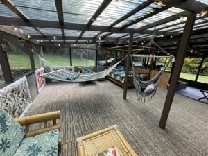a patio with two hammocks on a deck at Secluded house, Opening special in Pahoa
