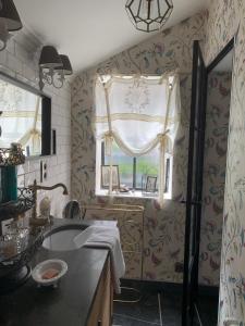 Un baño con lavabo y ventana. en Guestsuite Sir Joachim Bruges, en Brujas