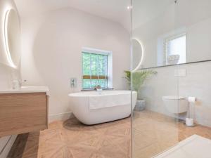 a white bathroom with a tub and a toilet at 2 Bed in Kirkby Lonsdale SZ093 in Kirkby Lonsdale