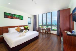 Quoc Cuong Center Da Nang Hotel by Haviland في دا نانغ: غرفة في الفندق مع سرير مع لاب توب عليه