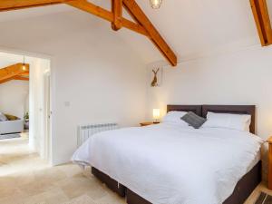 sypialnia z dużym białym łóżkiem i drewnianym sufitem w obiekcie 1 Bed in Falmouth 85826 w mieście Gwennap