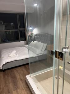 1 dormitorio con 1 cama con pared de cristal en Sky89Luxury RiverView_Sauna_Pool, en Ho Chi Minh
