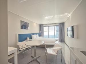 a hotel room with a bed and a table and chairs at Y Collection by UH FLAT Haeundae beach in Busan