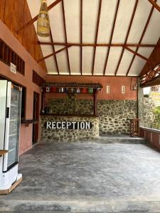 Asim Paris Guesthouse في بوكيت لاوانج: غرفة فارغة مع وجود اشارة استقبال في مبنى