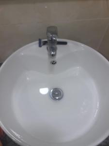 Fulidhoo Hathaa Retreat في فوليدهو: بالوعة حمام بيضاء وعليها صنبور