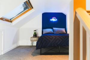 a bedroom with a bed with a blue head board at Spacious 2BD Maisonette with Lush Loft in Newquay in Newquay