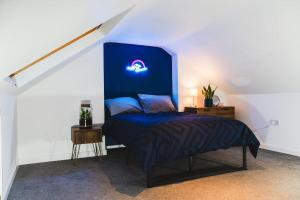 a bedroom with a bed with a blue head board at Spacious 2BD Maisonette with Lush Loft in Newquay in Newquay