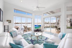 a living room with white furniture and a view of the ocean at Waterfront home with views, pool and walk to beach in Marco Island