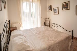 een wit bed in een slaapkamer met een raam bij La Mery Giò House - Fasano in Fasano +42 foto's