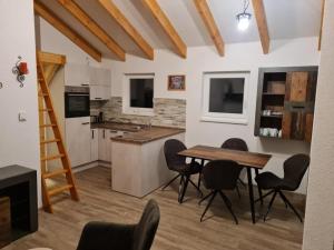 a kitchen with a wooden table and black chairs at NEU! Ferienhaus am See in Prötzel