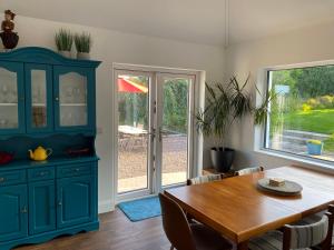 une salle à manger avec une table et un meuble bleu dans l'établissement mary-tim's Cromane Cross near Killorglin, à Killorglin