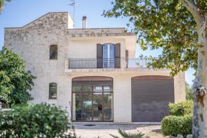 Una casa de ladrillo con un balcón encima. en La Mery Giò House - Fasano, en Fasano