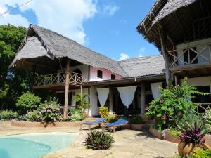 a resort with a swimming pool and a building at Che Che Vule by SeVi Exclusive Beach Villa in Matemwe