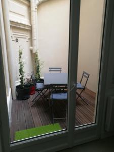 Blick auf eine Terrasse mit einem Tisch und Stühlen in der Unterkunft Charmant studio au coeur de Paris in Paris