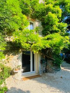 ein Steinhaus mit einem Tisch und einem Stuhl neben einer Tür in der Unterkunft Appart 40m2 dans maison - Proche Paris in Meudon