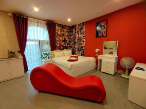 a bedroom with two beds and a red couch at Ngan Pho Studio & Hotel in Da Lat