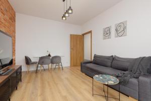 a living room with a couch and a table at Minimalist Apartment in Łódź With Parking Near Łódź Kaliska by Renters in Łódź