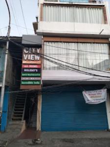 ein Geschäft mit einem Schild an der Seite eines Gebäudes in der Unterkunft CITY VIEW, Port Blair in Port Blair