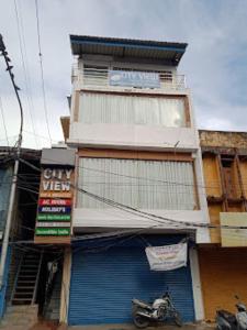 ein Gebäude mit einem Motorrad, das davor geparkt ist in der Unterkunft CITY VIEW, Port Blair in Port Blair