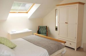 - une chambre avec un lit, une armoire et une chaise dans l'établissement Pleasure Row, à Alton