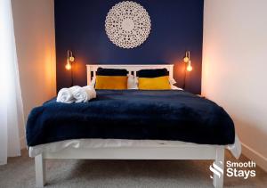 a bedroom with a bed with a blue blanket and yellow pillows at Stylish 2 Bed House In The Heart Of Clitheroe By Smooth Stays Short Lets & Serviced Accommodation With Parking in Clitheroe
