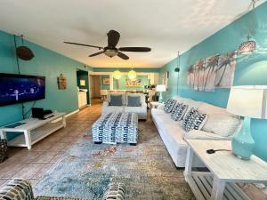 a living room with a couch and a flat screen tv at Leaward Isle Island Retreat in Key West