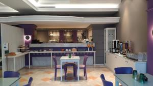 a restaurant with a table and chairs and a kitchen at Hotel Plaza in Kalamata