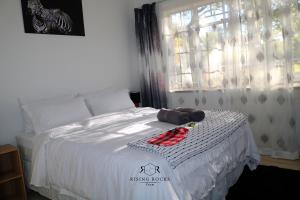a bedroom with a bed with a stuffed animal on it at Tranquil Mountain Cottage :Hikes/Boma/Animals/Pool in Magaliesburg