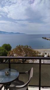 d'une table et de chaises sur un balcon avec vue sur l'océan. dans l'établissement Hotel Plaza, à Kalamata