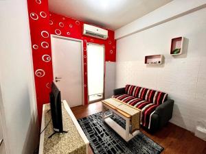 ein Wohnzimmer mit einem Sofa und einer roten Wand in der Unterkunft EarlyHome@Pakubuwono Terrace APT in Jakarta