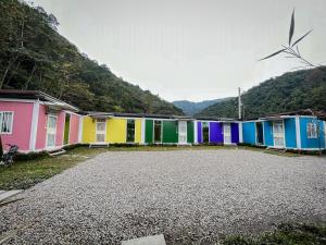 鉄木彩虹小屋 في Yü-lan: صف من المنازل الملونة مع محرك الرياح