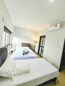 a bedroom with two beds and a window at Klebang GX Homestay Resort Pool View P0804 with Netflix, TVBox and Games in Malacca