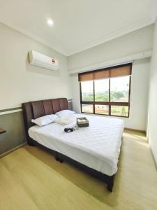 a bedroom with a large bed with white sheets and a window at Klebang GX Homestay Resort Pool View P0804 with Netflix, TVBox and Games in Malacca