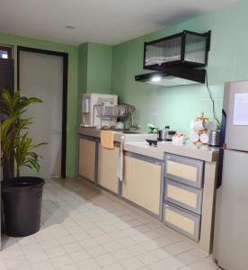 a kitchen with green walls and a refrigerator at Klebang GX Homestay Resort Pool View P0804 with Netflix, TVBox and Games in Malacca