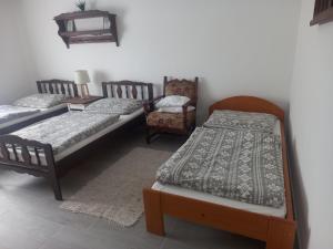 sypialnia z 2 łóżkami i krzesłem w obiekcie Borbély Vendégház w mieście Nagykanizsa
