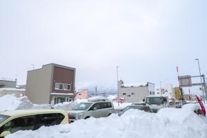 un estacionamiento lleno de mucha nieve en Ezo Fujiya Niseko House, en Kutchan