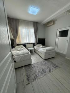 a hotel room with two beds and a window at Otel NİL FIRAT in Bursa