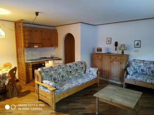 a living room with a couch and a kitchen at casa canazei in Alba di Canazei